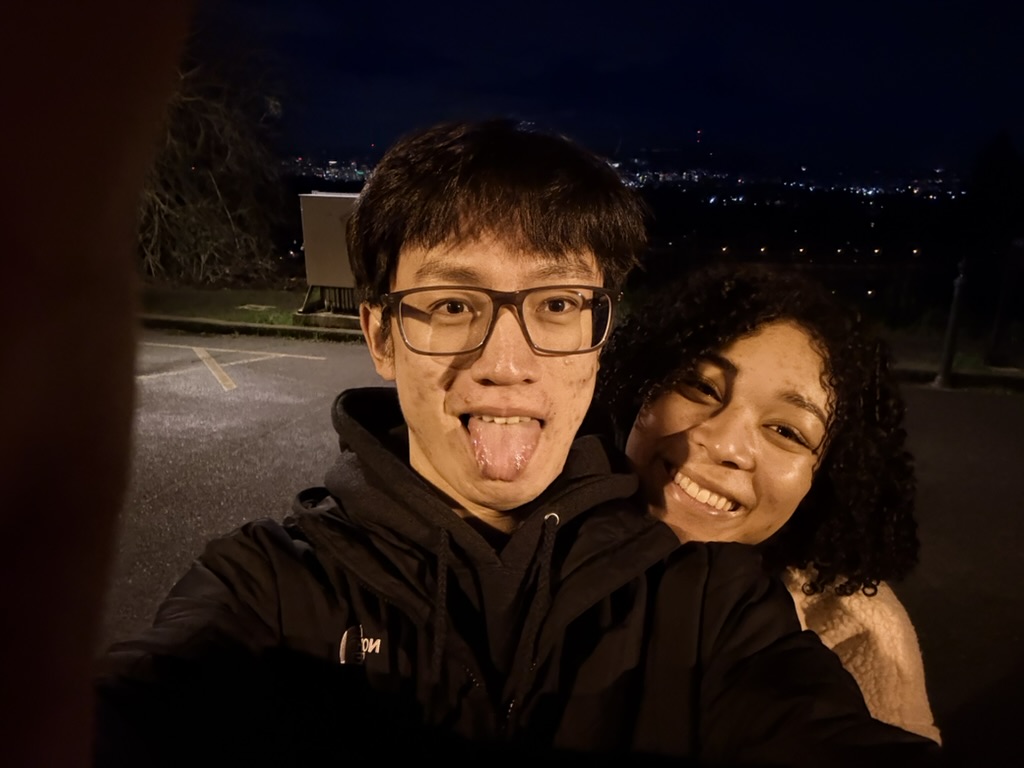 Makaia and Zuang taking a playful selfie at night